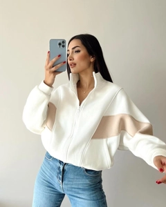 Detail view of women's loose half-zip sweatshirt with white and khaki color-block design