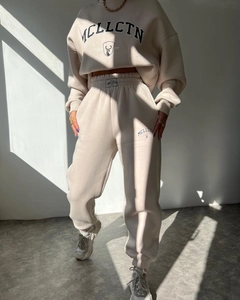 Detail of apricot fleece tracksuit showing the high-quality fabric texture and printed logo