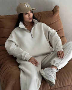 Detailed view of the half-zip collar and NY embroidery on a cream loungewear set