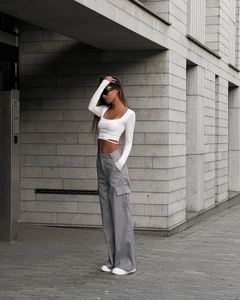 Detail of grey high-waisted wide-leg cargo pants with large side pockets and cropped top
