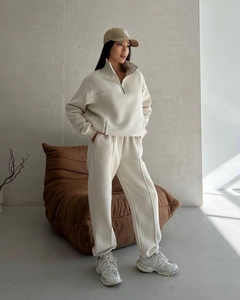 Detail view of the beige lounge set featuring a half-zip stand collar and ribbed cuffs