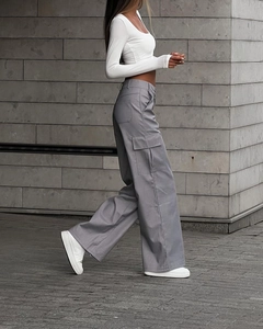 Outdoor shot of loose-fit grey cargo pants with side flap pockets and high waist