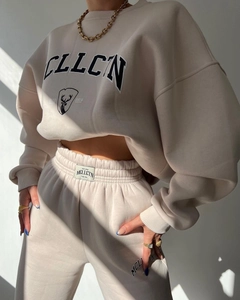 Detailed macro view of beige oversized sweatshirt with black elk print and premium texture