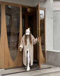 Streetstyle-Ansicht eines beigen Teddy-Mantels mit weißem Rollkragen und Plateaustiefeln