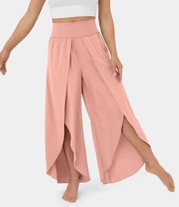 Detail view of high-waist yoga pants in coral pink with elegant front side slit design