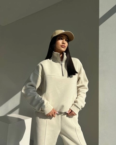 Detail view of cream lounge set featuring half-zip stand collar and seam-front pants