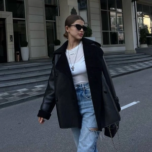 Veste en cuir noir pour femme avec bordure en peau lainée et jean bleu délavé usé