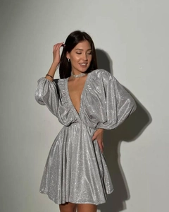 Detailed close-up of silver sequin texture on V-neck dress with puffy sleeves