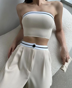 Detail showing contrast stripe waistband and decorative button on high waist trousers