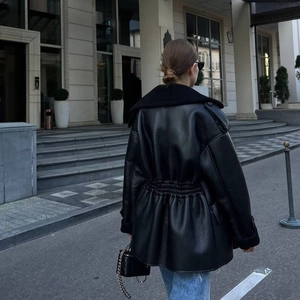 Détail de la taille élastiquée et de la silhouette d'une veste mi-longue en similicuir