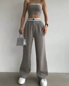 Detail of grey two-piece set featuring contrast striped waistband and wide-leg trousers