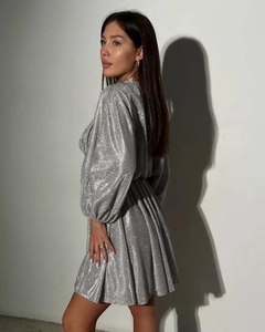 Close-up of sparkling silver sequin fabric and pleated V-neckline on a stylish mini dress
