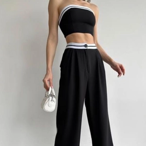Women's chic black two-piece set featuring a cropped vest and high-waist wide-leg pants