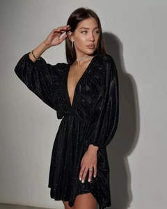 Detail of black V-neck dress featuring glittery fabric and elegant ruched texture