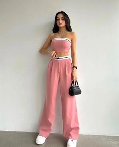 Detail of pink two-piece set featuring tube top and high waist wide leg pants with stripes