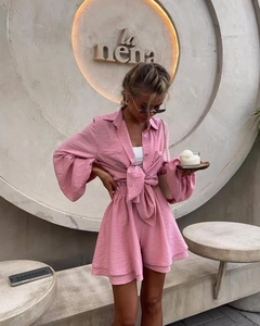 Detail of pink long sleeve shirt with knotted waist and pleated texture summer shorts