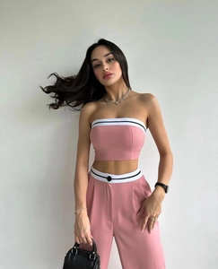 Detail of pink two-piece set featuring striped waist design and high-waisted wide-leg trousers