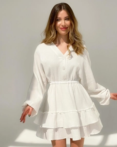 Detail of white V-neck dress showing texture, resin buttons and elastic waist