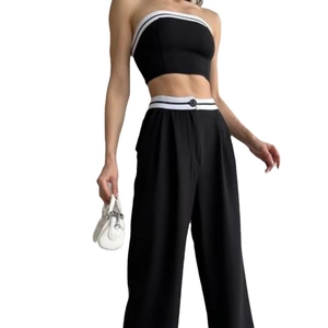 Women's black two-piece set featuring tube top and high waist wide leg pants with striped trim