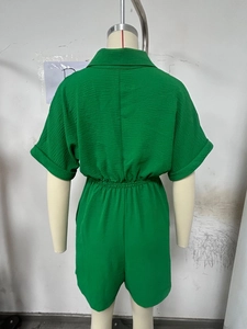 Detail of green short sleeve romper showing textured fabric and elastic waist design