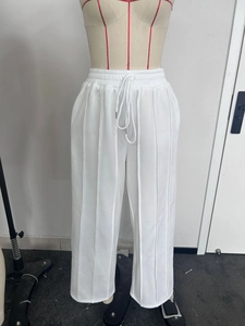 Détail du jogging blanc avec cordon de serrage et coutures verticales apparentes
