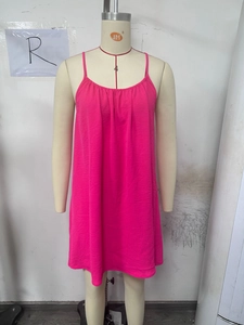 Detail of fuchsia summer mini dress featuring delicate pleats and thin straps on a mannequin