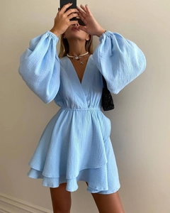 Detail of light blue V-neck dress featuring puff sleeves and textured ruffles