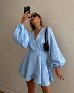 Detail view of light blue mini dress featuring puff sleeves and textured fabric