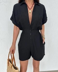 Detail showing high-waisted black romper with elastic waist and button-down front