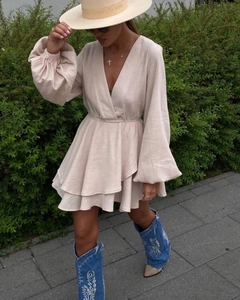 Detail of V-neck apricot mini dress with ruffled hem and long lantern sleeves