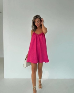 Detail of rose red backless mini beach dress with thin straps and V-neckline texture
