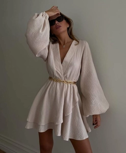 Detail of elegant beige V-neck mini dress with lantern sleeves and gold waist belt