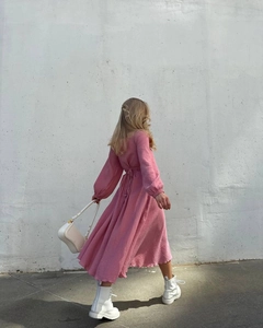 Close-up of the elegant criss-cross tie-back design on a pink textured midi dress