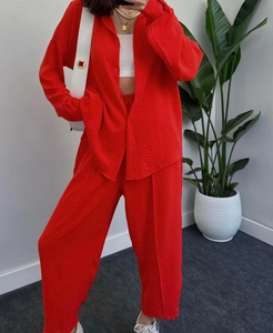 Detail of red two-piece set featuring textured lapel shirt and matching wide-leg trousers