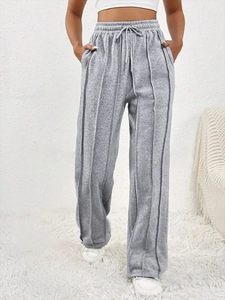 Détail du jogging gris avec taille à cordon et coutures verticales sur les jambes