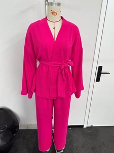 Detailed view of fuchsia two-piece lounge set with V-neck belted top and matching pants