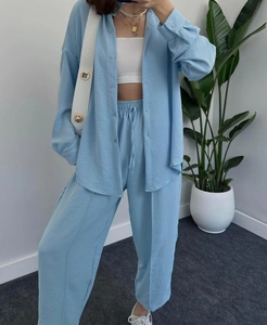 Close-up detail of light blue crepe fabric texture on loose shirt and drawstring pants