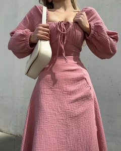 Detail of light pink square neck dress featuring smocked fabric and lantern sleeves