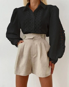 Detail of black long sleeve blouse with lace embroidery and high waist khaki shorts