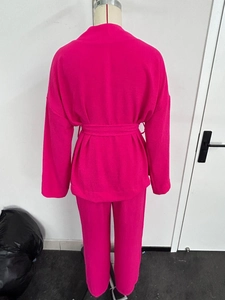 Detail view of rose red loungewear set featuring textured fabric and belted waist top