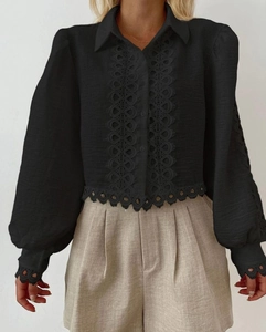 Detail of black long sleeve shirt with exquisite lace eyelet trim on hem and cuffs