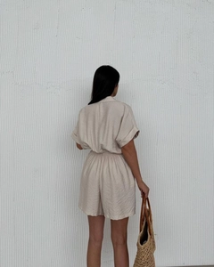 Detail of beige cotton-linen short sleeve romper with elastic waist and woven beach bag