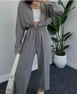 Detail of grey pleated fabric texture on elastic waistband pants with adjustable drawstring