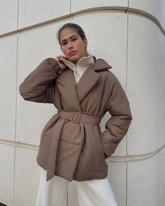Detail of winter puffer coat with adjustable waist belt and stylish buckle closure