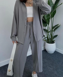 Detail of grey crinkle fabric casual two-piece set featuring shirt and wide-leg trousers