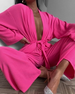 Detailed texture of hot pink crepe fabric on a loose two-piece V-neck lounge set