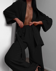 Detail of black textured crepe lounge set featuring wide-leg trousers and a kimono cardigan
