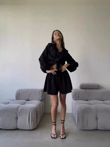 Women's 2-piece black summer set featuring long sleeve button shirt and ruffle shorts