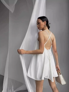 Elegant white backless summer beach dress with thin crisscross straps and A-line silhouette