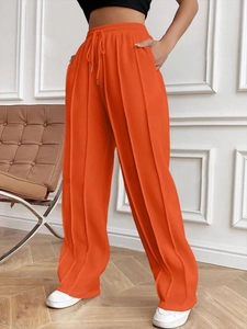Pantalon large orange à taille haute pour femme avec cordon et texture plissée verticale